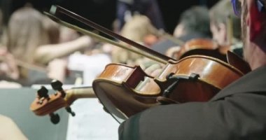 Konser öncesi klasik müzik provası sırasında keman çalan müzisyen
