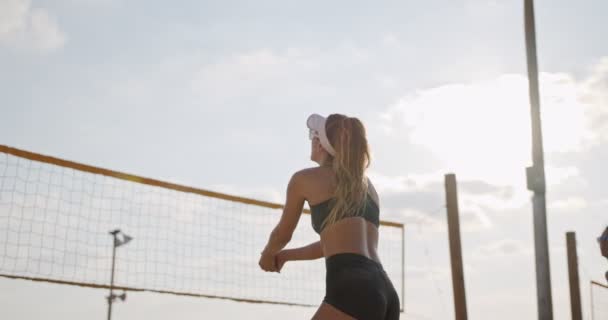 Movimiento lento de las mujeres jugando voleibol de playa durante la puesta del sol — Vídeo de stock