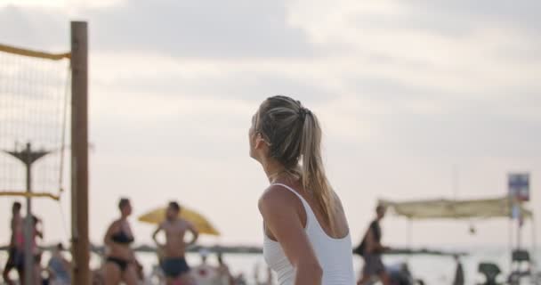 Movimiento lento de las mujeres jugando voleibol de playa durante la puesta del sol — Vídeos de Stock