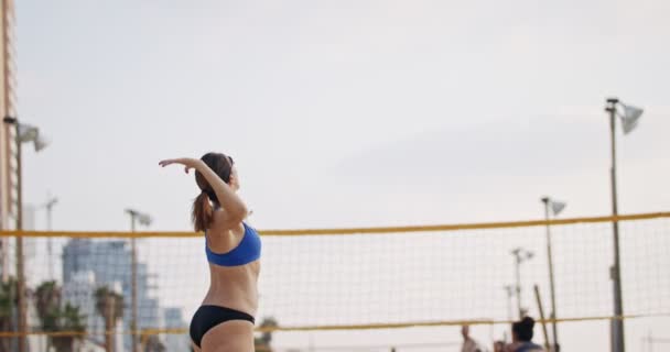 Movimiento lento de las mujeres jugando voleibol de playa durante la puesta del sol — Vídeos de Stock