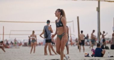 Gün batımında plaj voleybolu oynayan kadınların yavaş hareketi