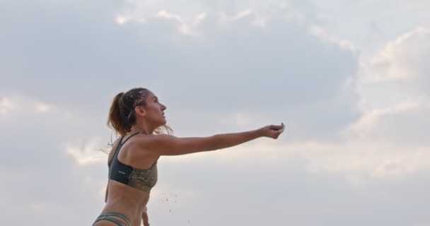 Movimento lento da mulher jogando vôlei de praia durante o pôr do sol — Vídeo de Stock