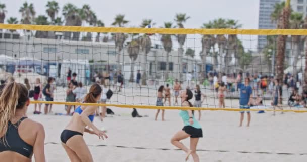 Movimiento lento de las mujeres jugando voleibol de playa durante la puesta del sol — Vídeo de stock