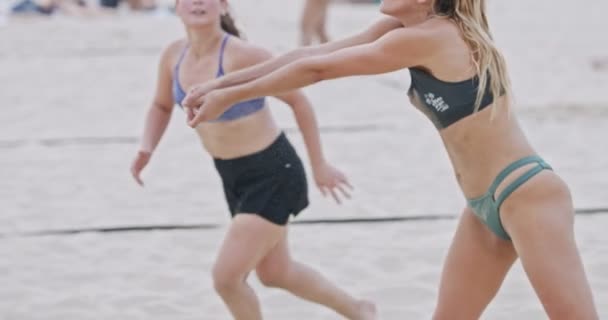 Slow Motion av kvinnor som spelar beachvolleyboll under solnedgången — Stockvideo