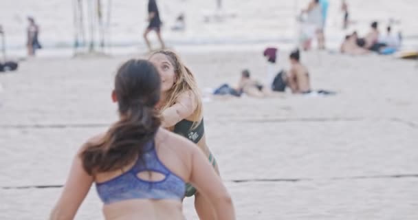 Movimiento lento de las mujeres jugando voleibol de playa durante la puesta del sol — Vídeos de Stock