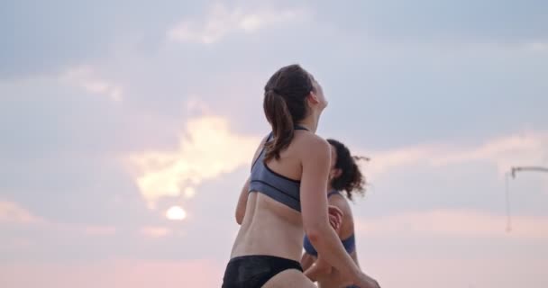 Slow Motion av kvinnor som spelar beachvolleyboll under solnedgången — Stockvideo