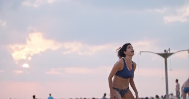 Slow Motion van vrouwen die beachvolleybal spelen tijdens zonsondergang — Stockvideo