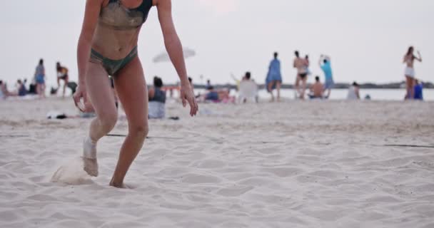 Vrouwelijk beachvolleybalspeler duiken op het zand tijdens een spel — Stockvideo