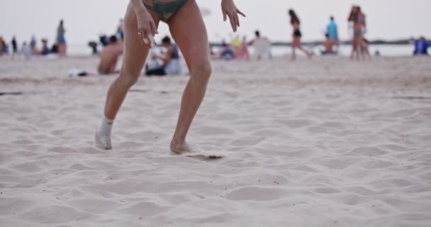 Пляжная волейболистка ныряющая на песок во время игры — стоковое видео