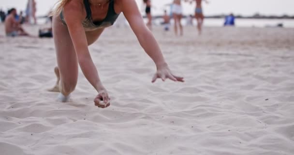 Kvinnlig beachvolleybollspelare dykning på sanden under ett spel — Stockvideo