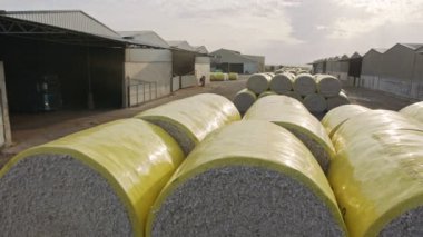 Large stacks of cotton bales at a cotton gin after harvest