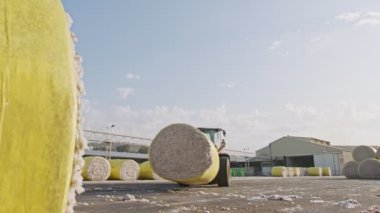 İşlemden önce pamuk balyalarını pamuk cine yükleyen büyük traktör