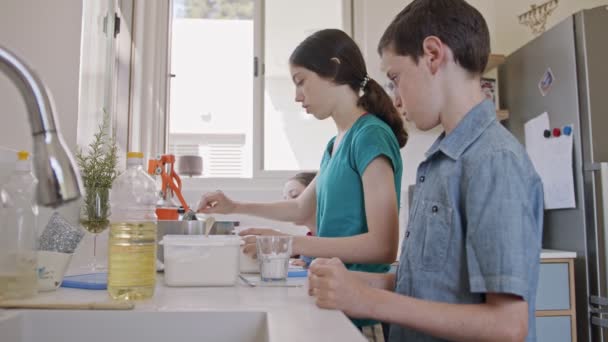 Kinderen bereiden en mixen ingrediënten voor pannenkoeken in de keuken — Stockvideo