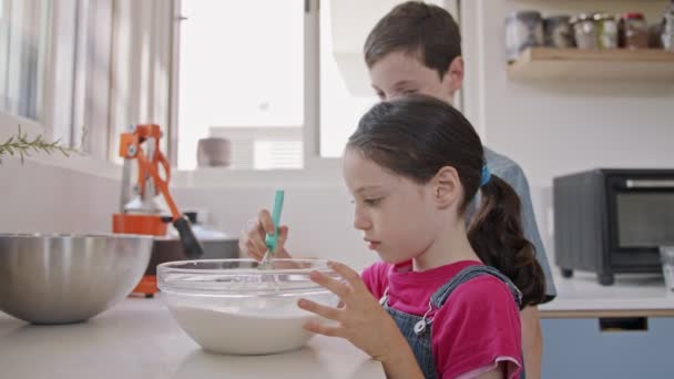 Kinderen bereiden en mixen ingrediënten voor pannenkoeken in de keuken — Stockvideo