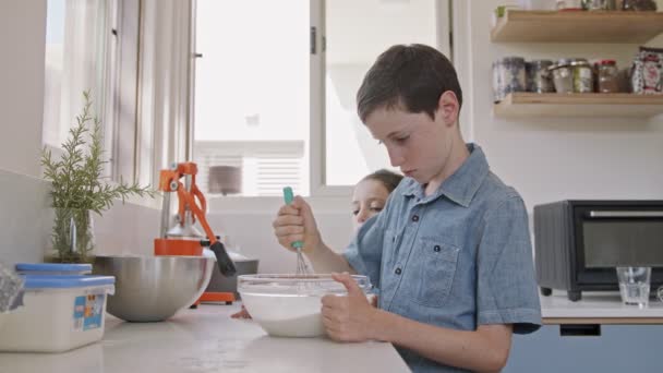 Enfants préparant et mélangeant des ingrédients pour les crêpes dans la cuisine — Video