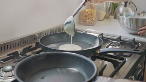 フライパンを使って台所でパンケーキを準備する若い子供たち — ストック動画