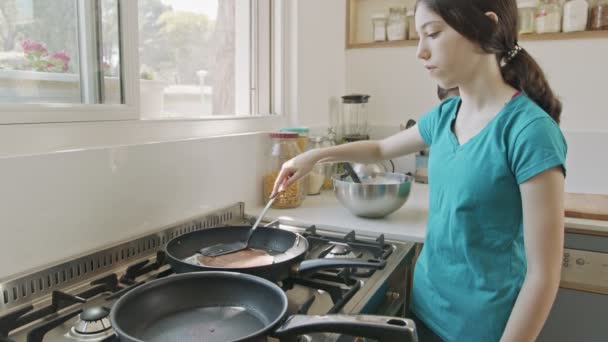 Молодые дети готовят блины на кухне на сковородке. — стоковое видео