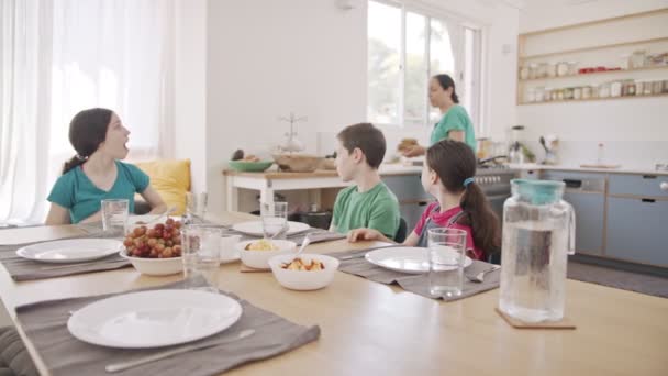 Moeder serveert ontbijt - een bord vol pannenkoeken voor haar kinderen — Stockvideo