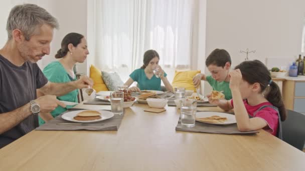 Familie die pannenkoeken en fruit als ontbijt eet — Stockvideo