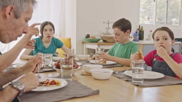 Trei copii iau micul dejun cu clatite si fructe impreuna cu parintii lor — Videoclip de stoc