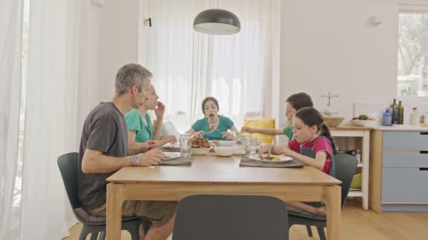 Familjen äter pannkakor och frukter till frukost — Stockvideo
