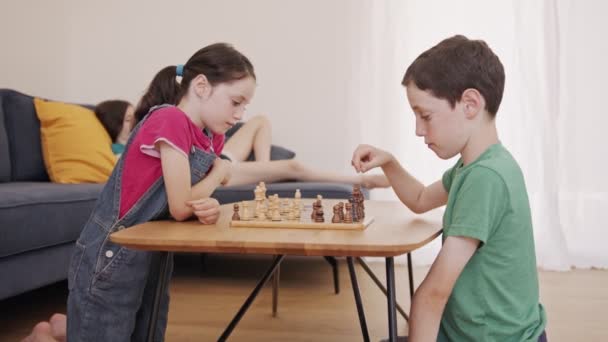Çocuklar oturma odasındaki masada satranç oynuyorlar. — Stok video