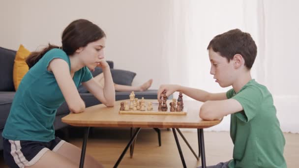Kleine Kinder spielen Schach auf dem Wohnzimmertisch — Stockvideo