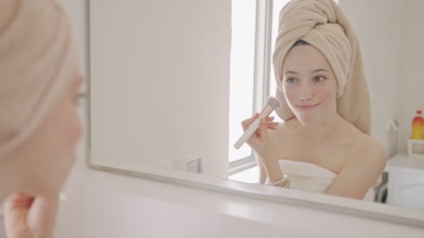 Teenage girl applying makeup in front of the bathroom mirror — Stock Video