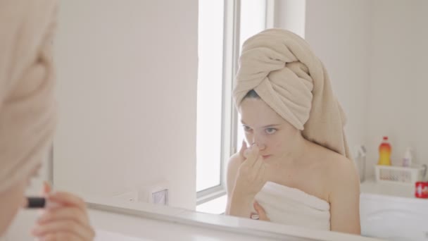 Tini lány alkalmazó smink előtt a fürdőszoba tükör — Stock videók