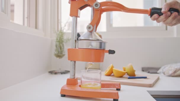 Super slow motion av färsk apelsinjuice pressas med hjälp av en manuell klämma — Stockvideo