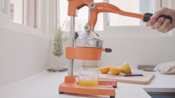 Movimento super lento de suco de laranja fresco espremido usando um espremedor manual — Vídeo de Stock