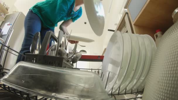 POV tiro de uma mulher encher a máquina de lavar louça com pratos sujos — Vídeo de Stock