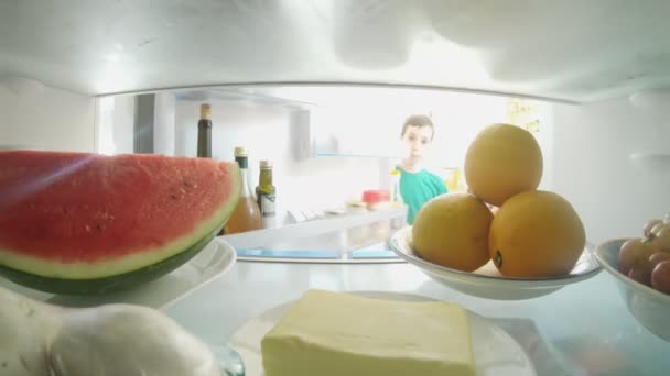 POV shot from inside a refrigerator of boy opening the door and taking out food — Stock Video