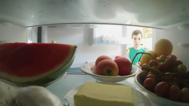 POV tiro de dentro de um refrigerador de menino abrindo a porta e tirando comida — Vídeo de Stock