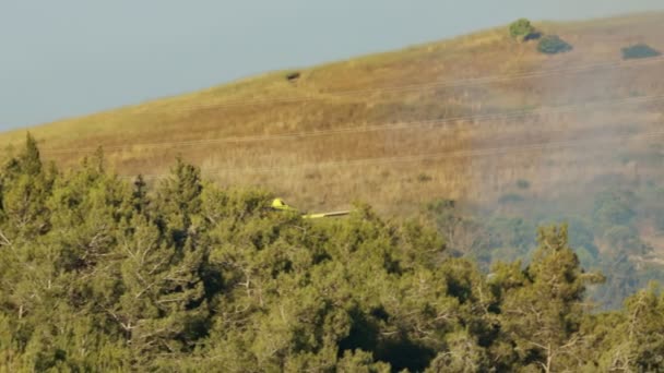 Löschflugzeug wirft bei Waldbrand in den Hügeln Brandschutzmittel ab — Stockvideo