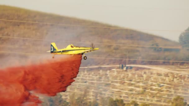 Löschflugzeug wirft bei Waldbrand in den Hügeln Brandschutzmittel ab — Stockvideo