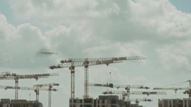 Binaların üzerinde çalışan vinçleri olan büyük bir inşaat alanı.