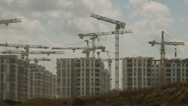 Duży plac budowy z wieloma dźwigami pracującymi nad budynkami — Wideo stockowe