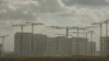 Binaların üzerinde çok sayıda vinç çalışan büyük bir inşaat alanının zaman çizelgesi