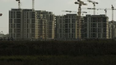 Binaların üzerinde çalışan vinçleri olan büyük bir inşaat alanı.