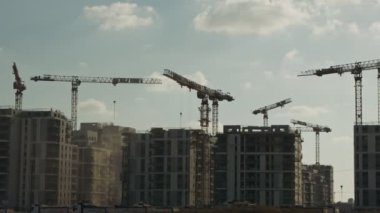 Binaların üzerinde çalışan vinçleri olan büyük bir inşaat alanı.
