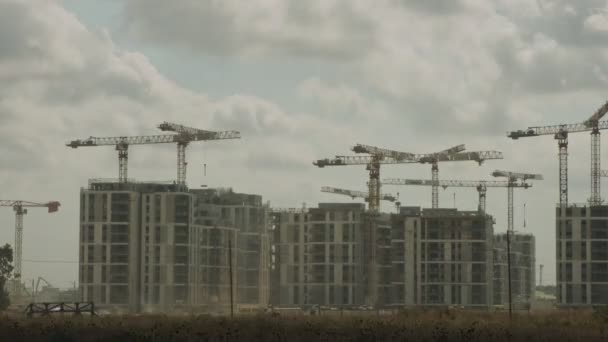 Timelapse de um grande canteiro de obras com muitos guindastes trabalhando sobre edifícios — Vídeo de Stock