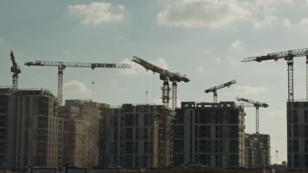 Grand chantier de construction avec de nombreuses grues travaillant sur des bâtiments — Video