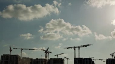 Binaların üzerinde çalışan vinçleri olan büyük bir inşaat alanı.