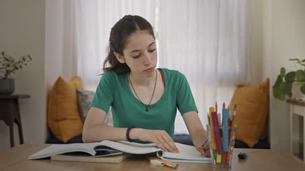 Dospívající dívka sedí doma a připravuje domácí úkoly do školy — Stock video