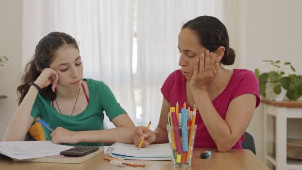Мама помогает своей дочери-подростку подготовить домашнее задание — стоковое видео