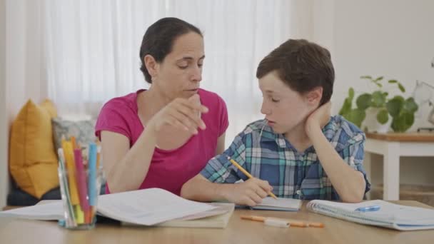 Madre ayudando a su hijo pequeño a preparar la tarea durante la educación en casa — Vídeos de Stock