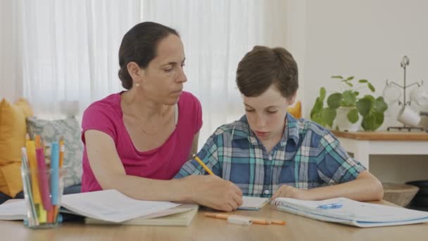 Moeder helpen haar jonge zoon voor te bereiden huiswerk tijdens thuisonderwijs — Stockvideo