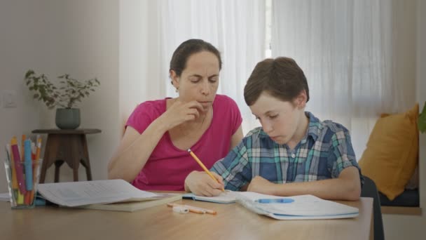 Madre ayudando a su hijo pequeño a preparar la tarea durante la educación en casa — Vídeos de Stock