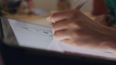 Tablet bilgisayar ve elektronik kalem kullanan genç bir kız çiziyor.